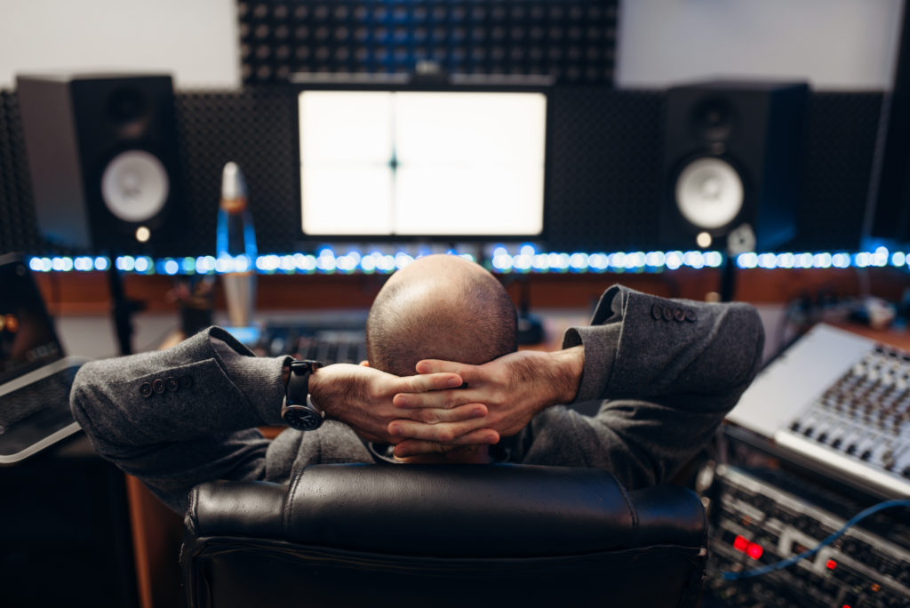 Male sound engineer at remote control, back view